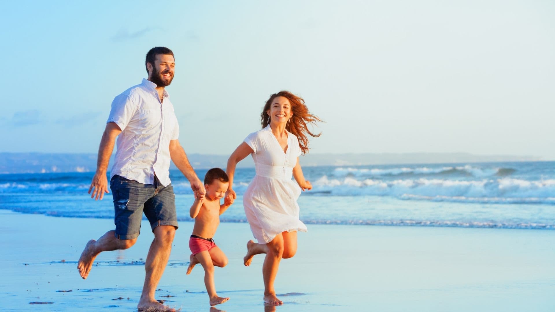 Happy family running on a Hawaii beach