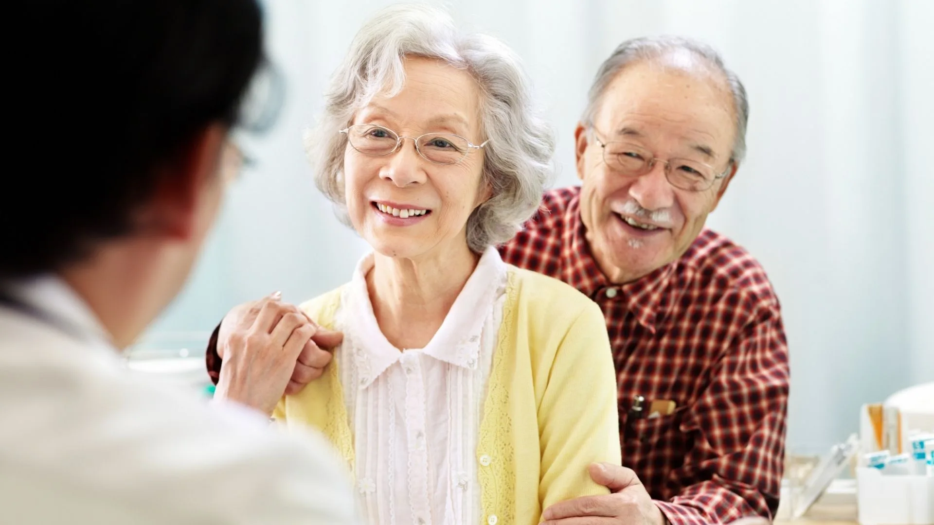 Elderly couple smiling with their physician